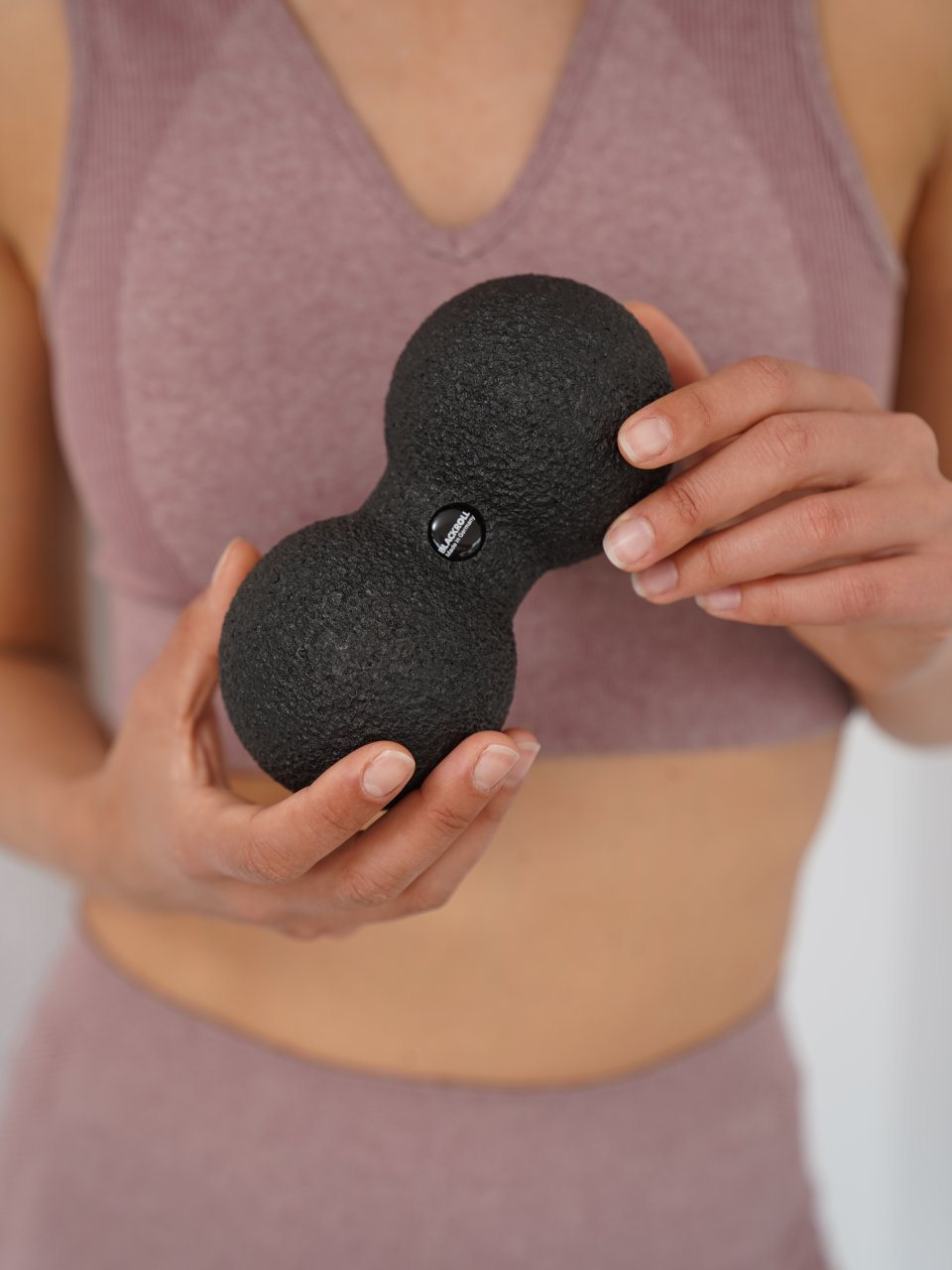 Woman holding a DUOBALL 08 fascia ball in her hand