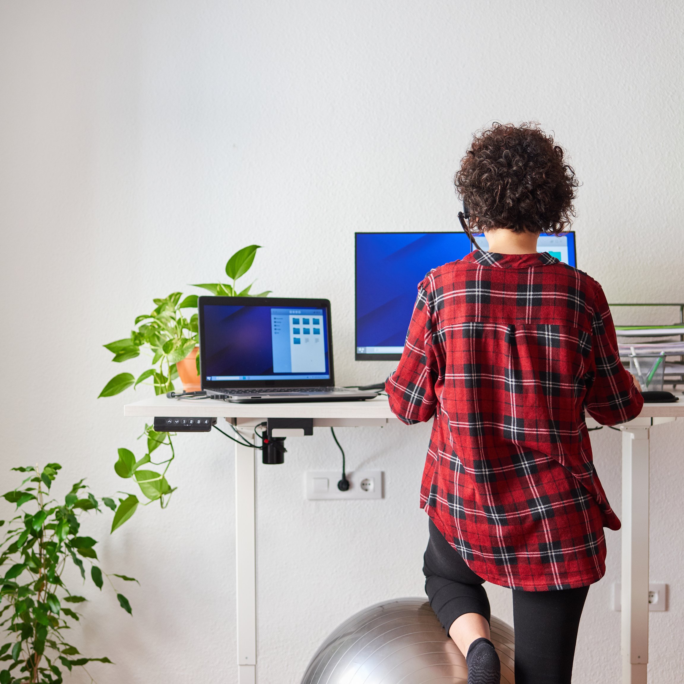 Femme à un poste de travail ergonomique avec un bureau debout