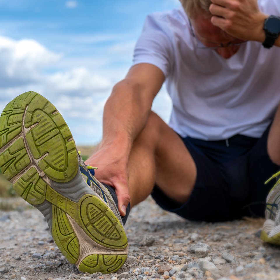 Jogger sitzt verletzt auf einem Feldweg