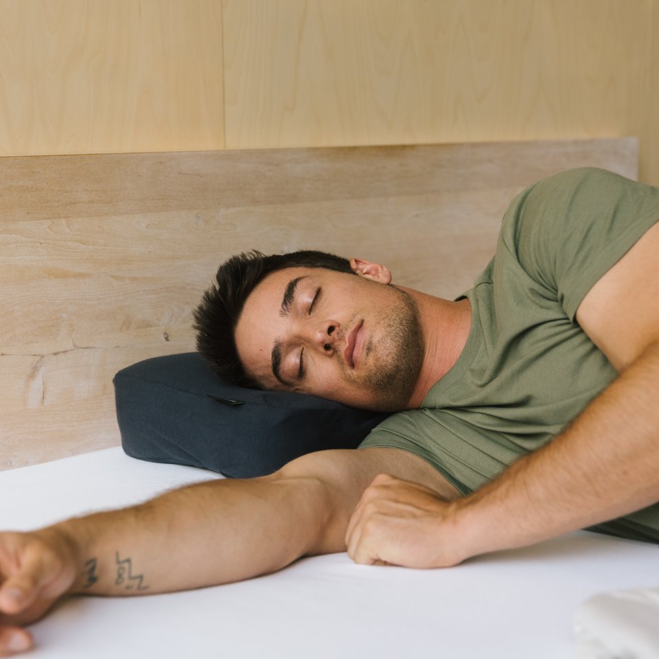 Schlafender Mann auf schwarzem Recovery Pillow