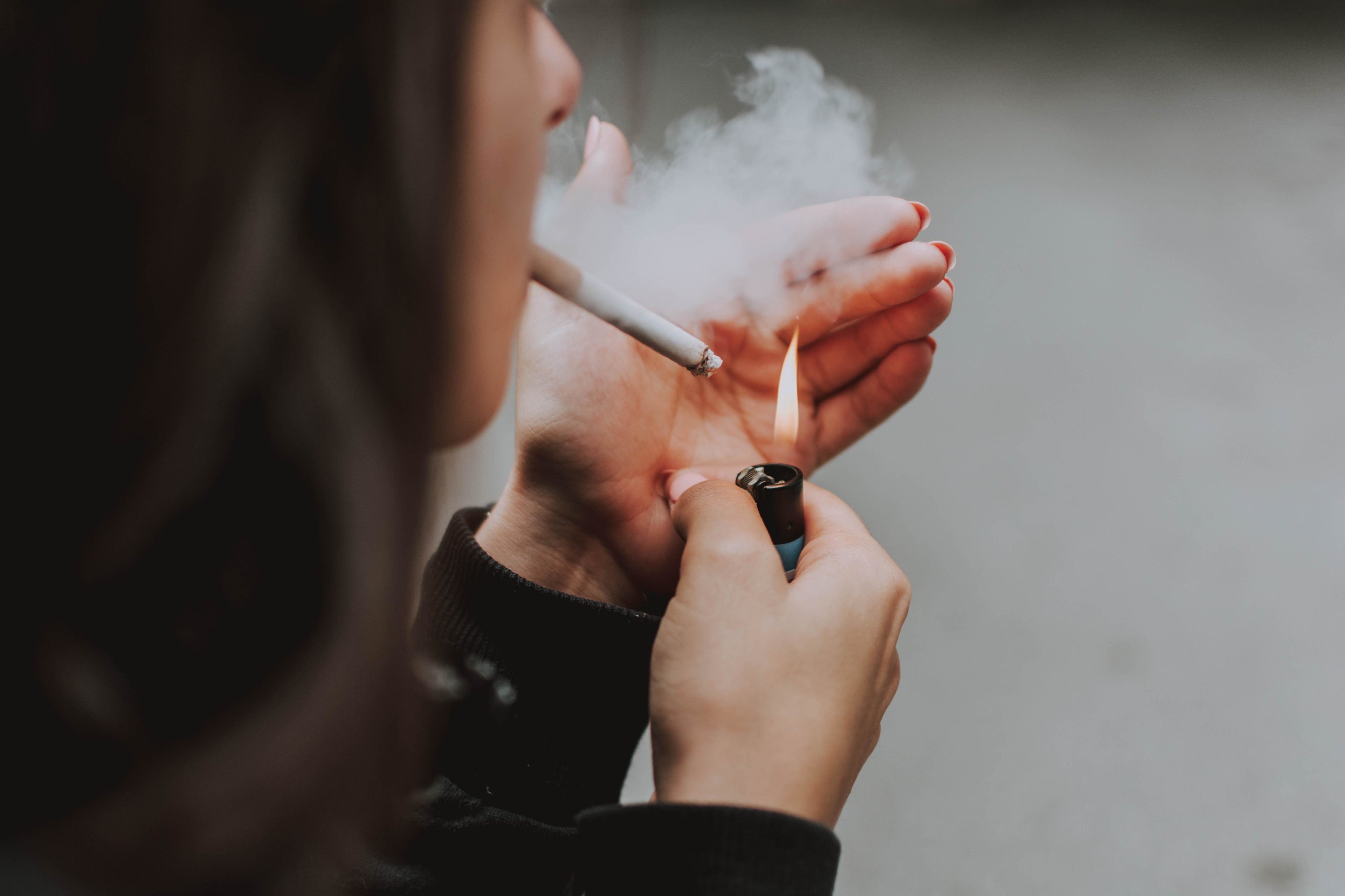Interdiction de fumer, une femme allume une cigarette