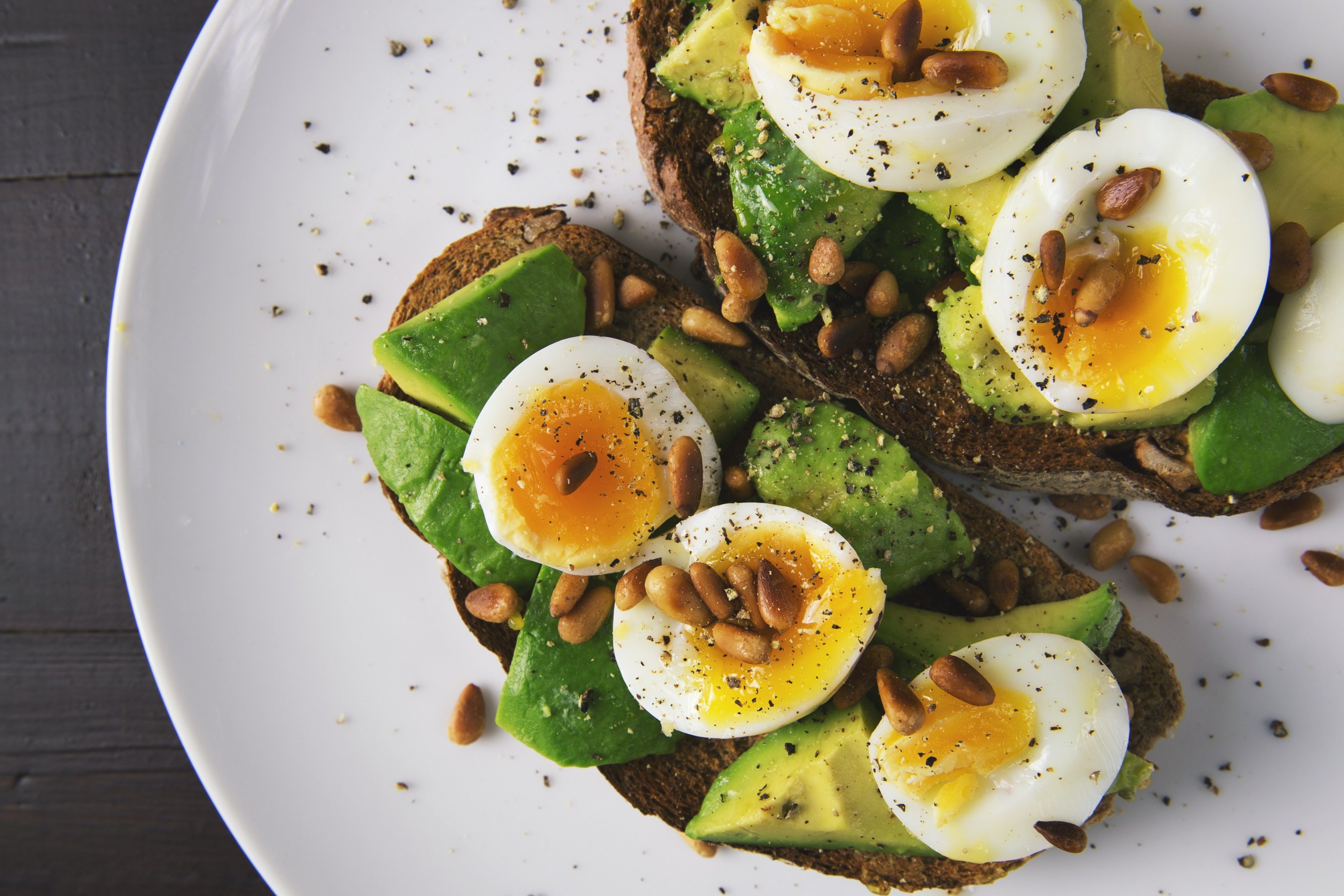 Plate with toasted whole-grain bread, topped with egg and avocado