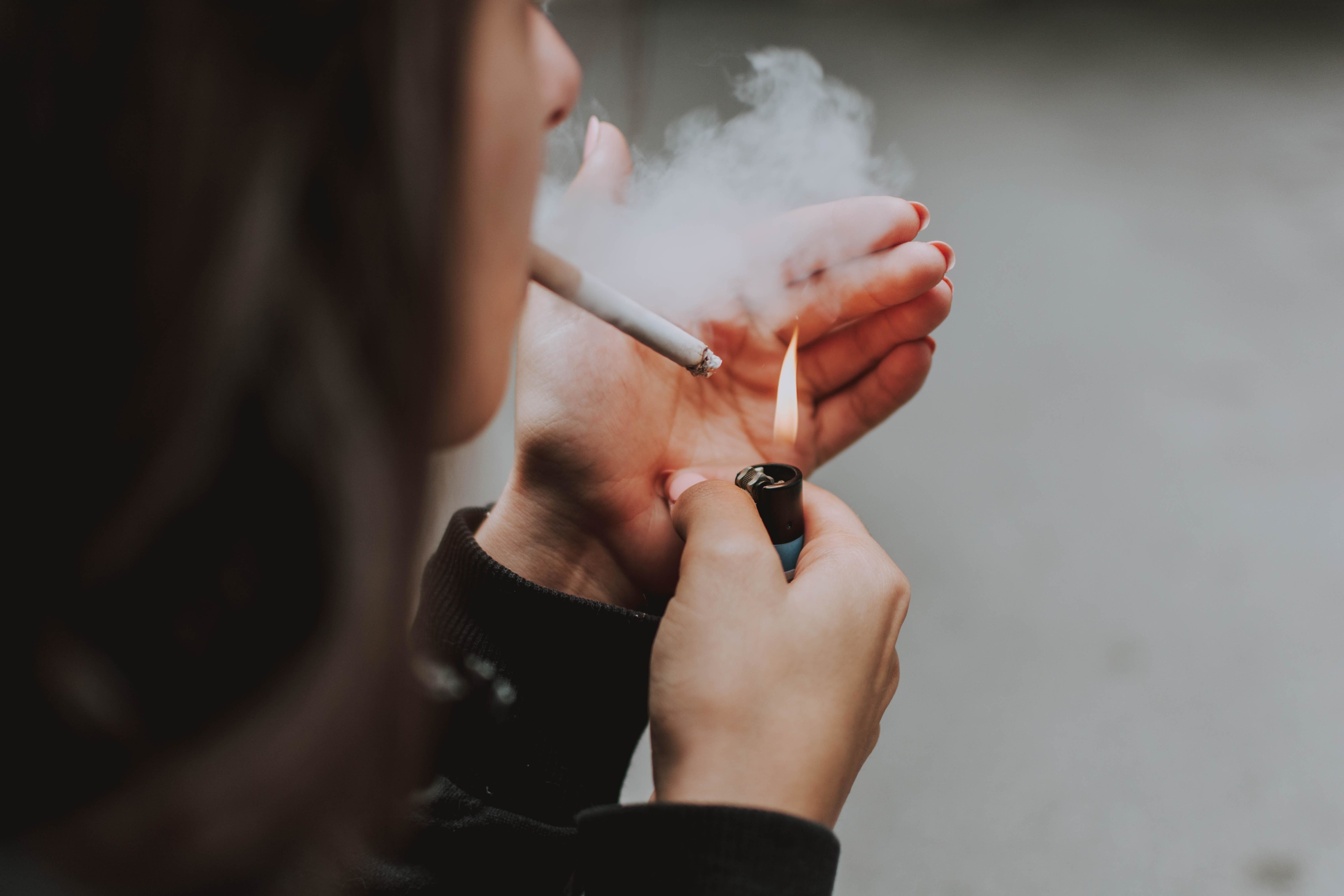 No smoking; woman lights a cigarette