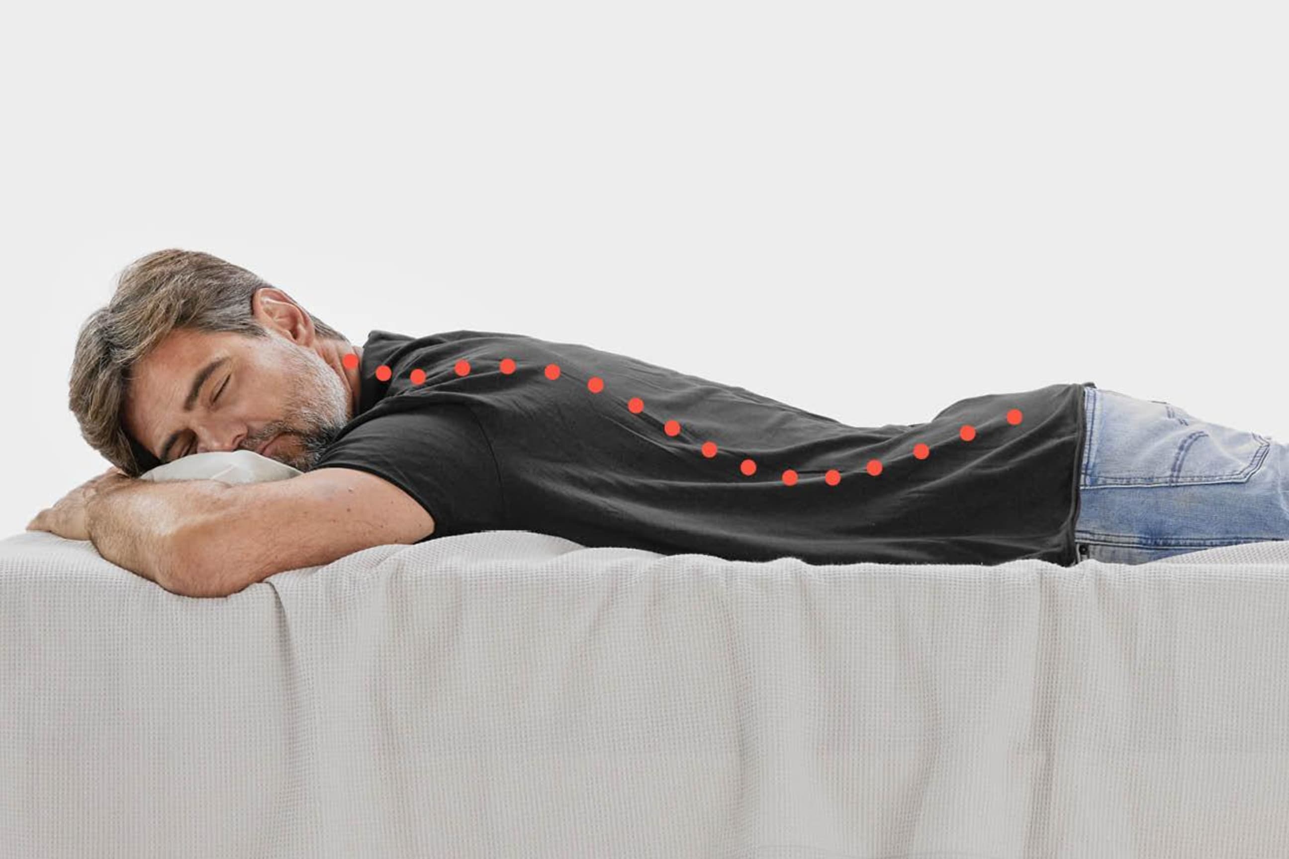 Un homme est allongé sur le lit en position ventrale avec le dos courbé