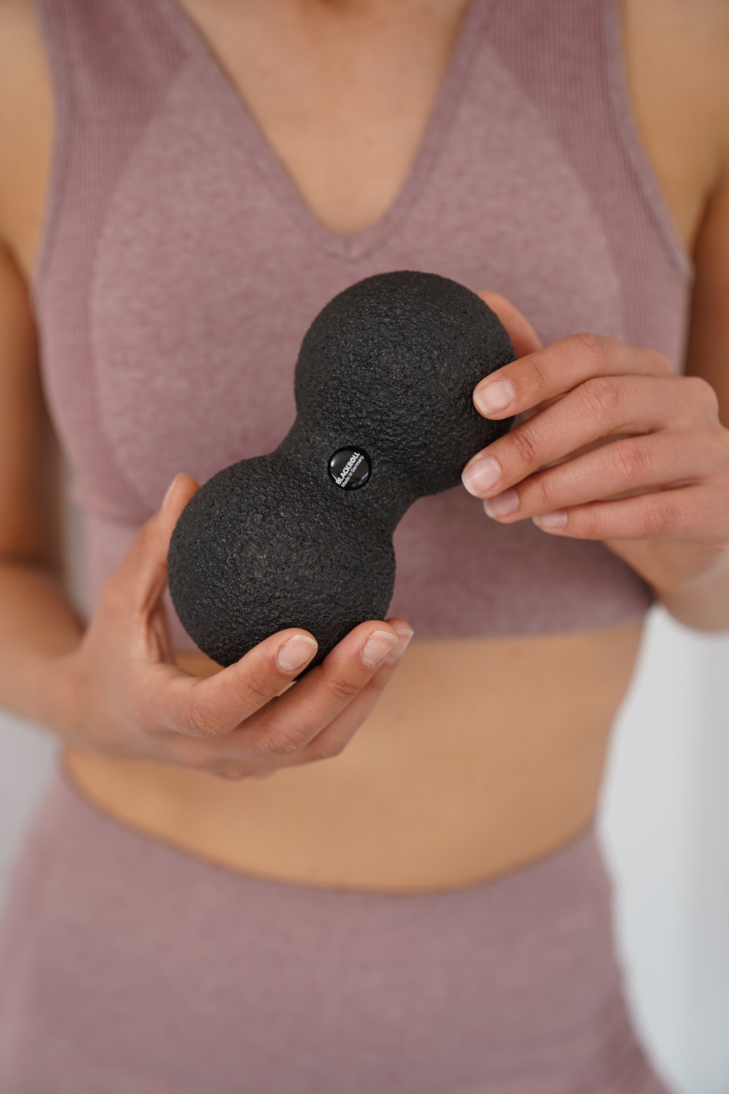 Frau hält DUOBALL 08 Faszienball in der Hand