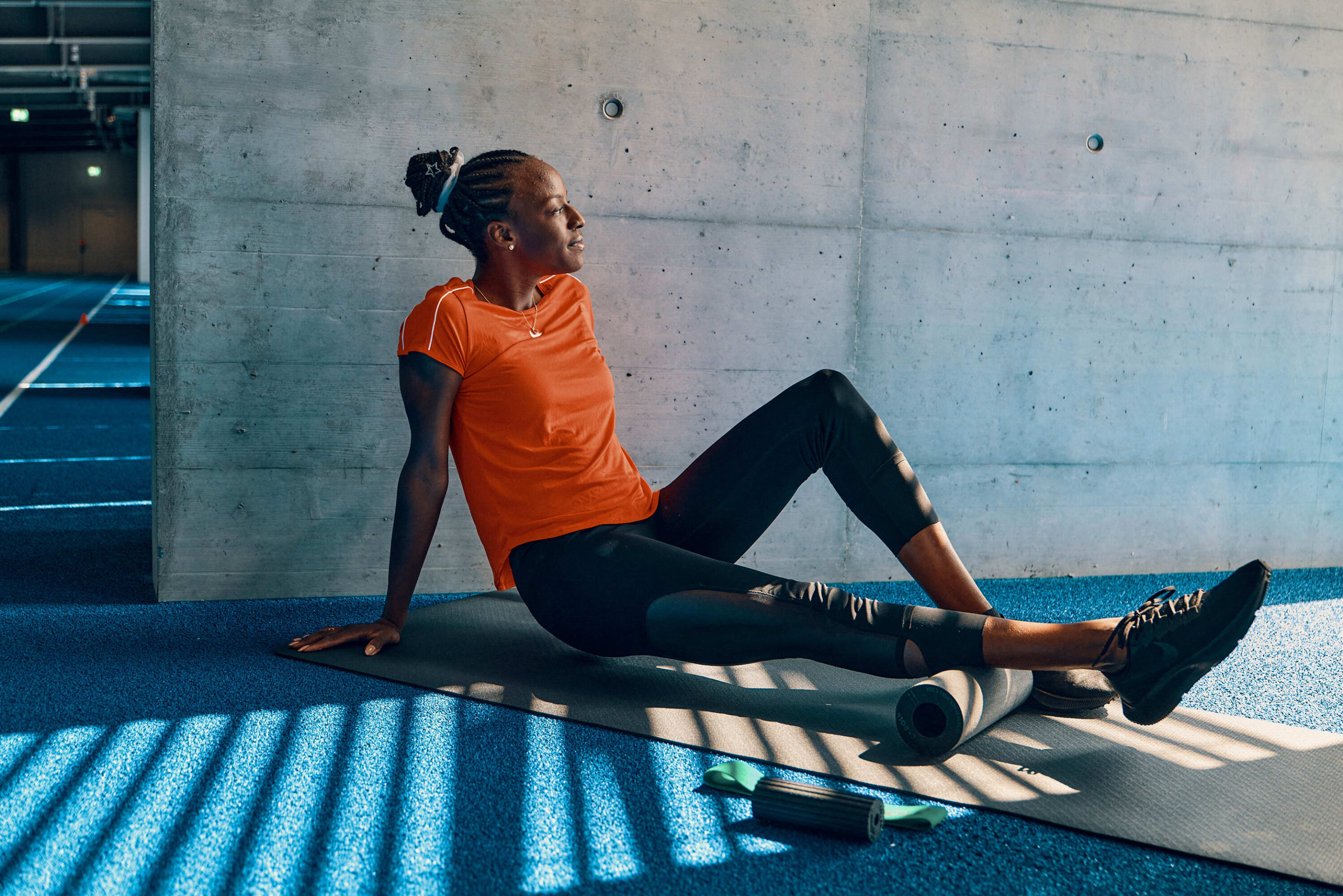 Track and field athlete, Yasmin Giger doing track and field cool-down & stretching exercises with BLACKROLL® products.
