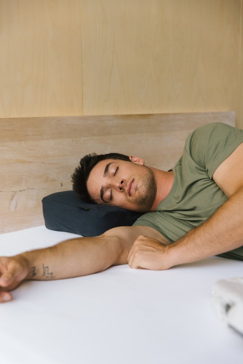 Schlafender Mann auf schwarzem Recovery Pillow