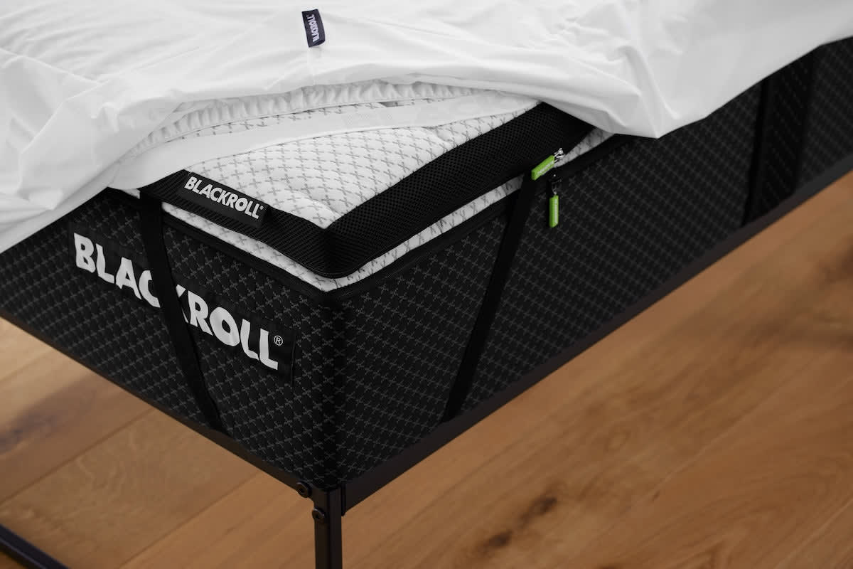 BLACKROLL® MATTRESS PROTECTOR unter dem Spannbettlaken auf einer Matratze angebracht