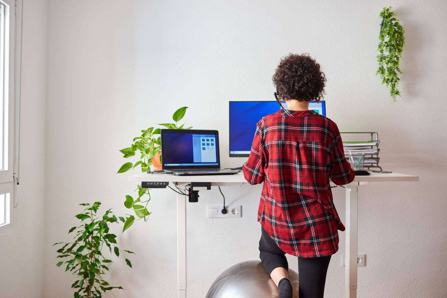 Frau an ergonomischem Arbeitsplatz mit Stehtisch