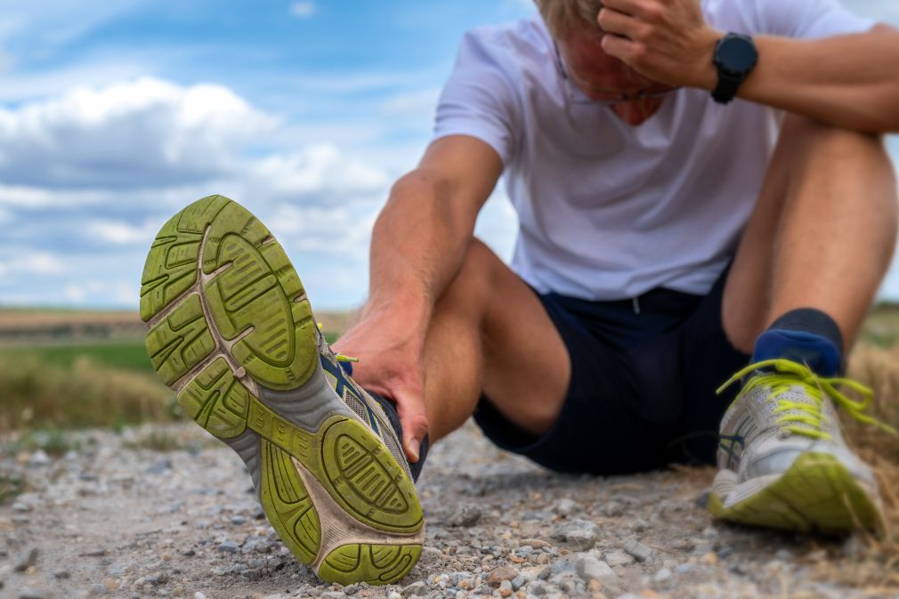 Jogger sitzt verletzt auf einem Feldweg
