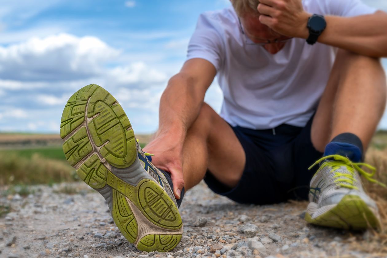 Jogger sitzt verletzt auf einem Feldweg