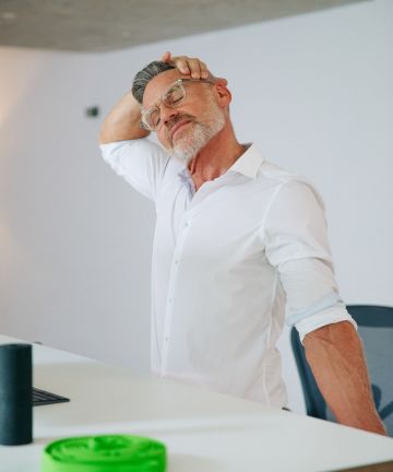 Man doing stretching exercises in office